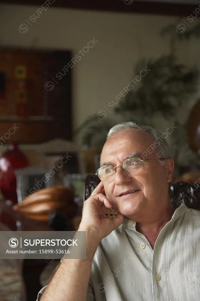 Senior Hispanic man sitting in chair