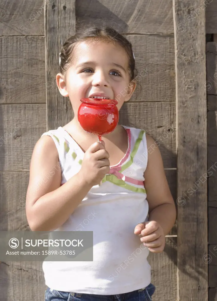 Hispanic girl eating candied apple
