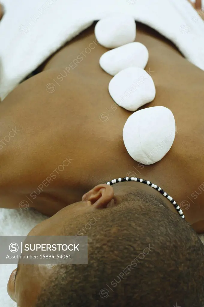 African man receiving spa stone treatment