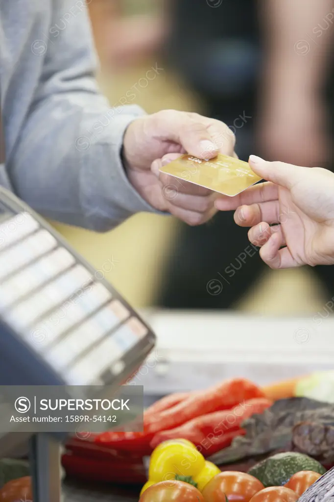 Man paying with credit card at grocery store
