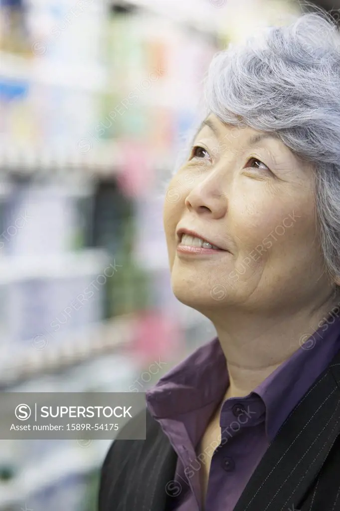 Senior Asian woman looking up