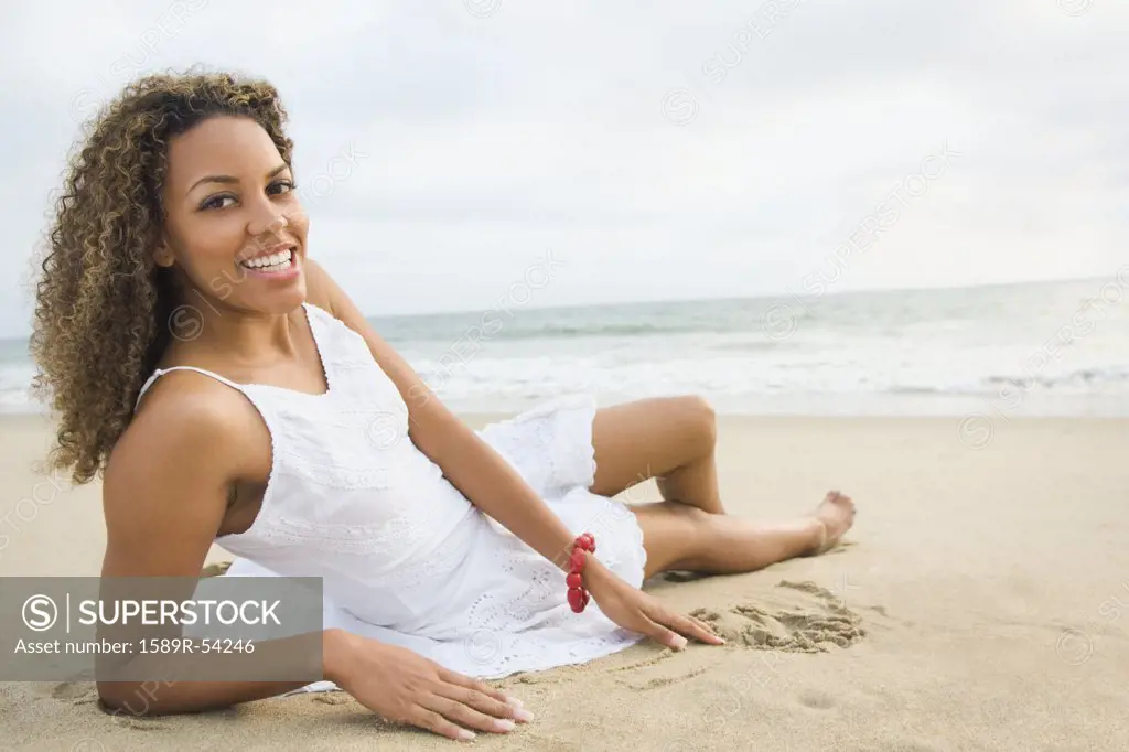 African woman laying on sand