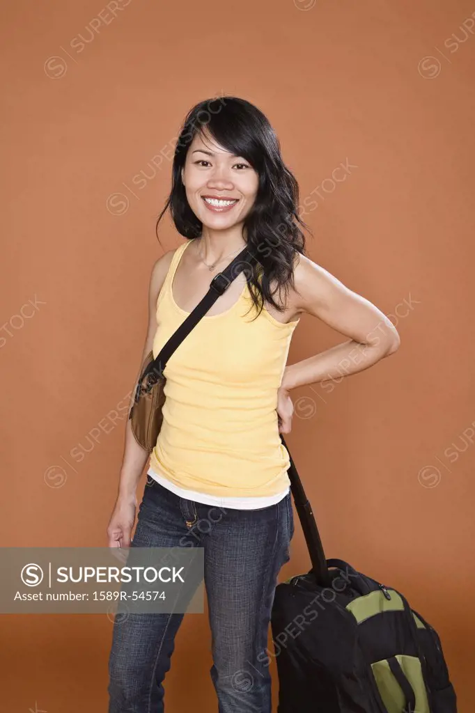 Asian woman holding suitcase