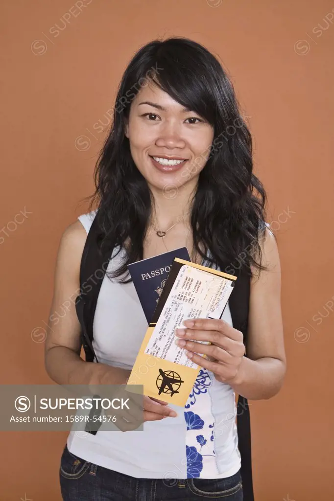 Asian woman holding passport and airplane ticket