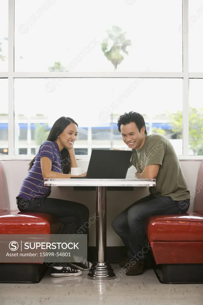 Asian couple looking at laptop