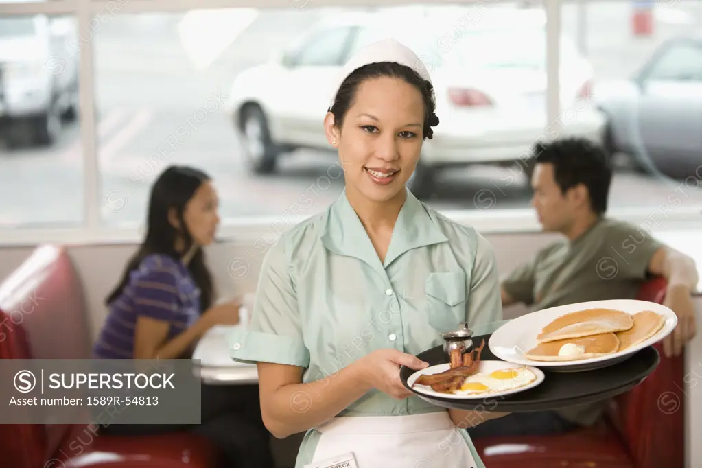 Asian waitress holding tray of food