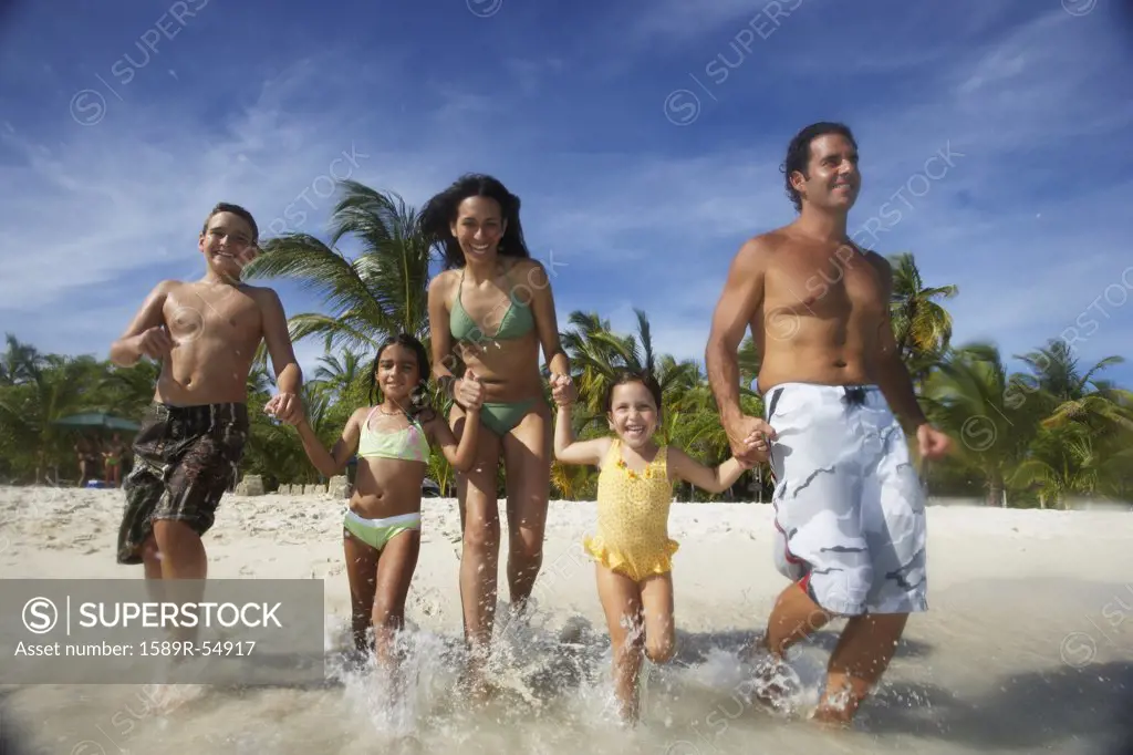 Hispanic family running into water