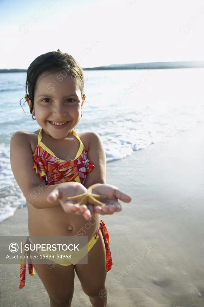 Hispanic girl holding starfish