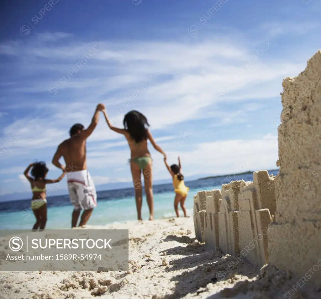 Hispanic family with sand castle in foreground