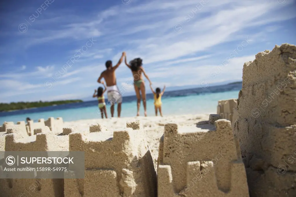 Hispanic family with sand castle in foreground