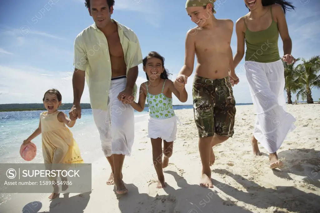 Hispanic family holding hands at beach