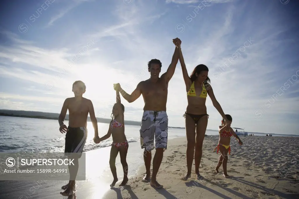 Hispanic family holding hands at beach