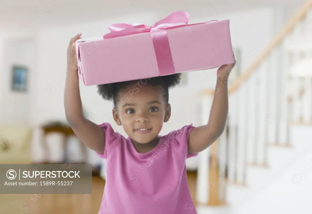 Mixed Race girl holding gift on head