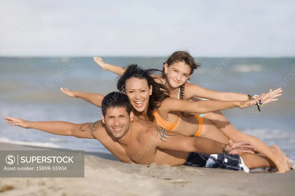 Hispanic family laying on beach