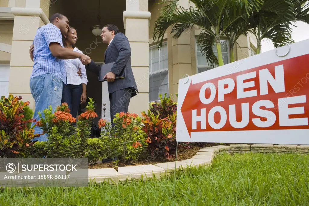 African couple shaking hands with Hispanic real estate agent