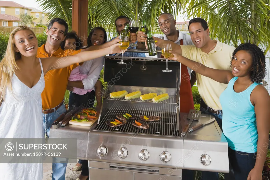 Multi-ethnic friends toasting over barbecue grill