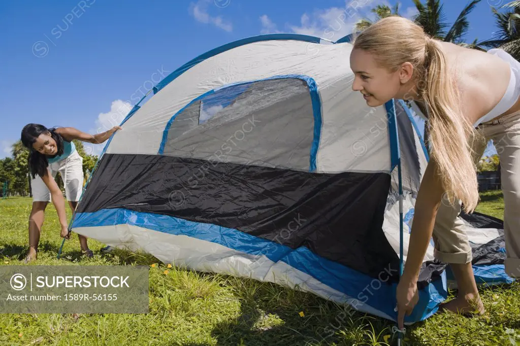 Hispanic women setting up tent
