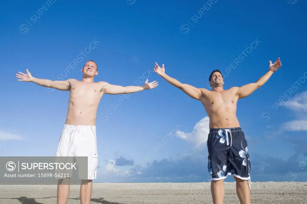 Multi-ethnic men with arms outstretched
