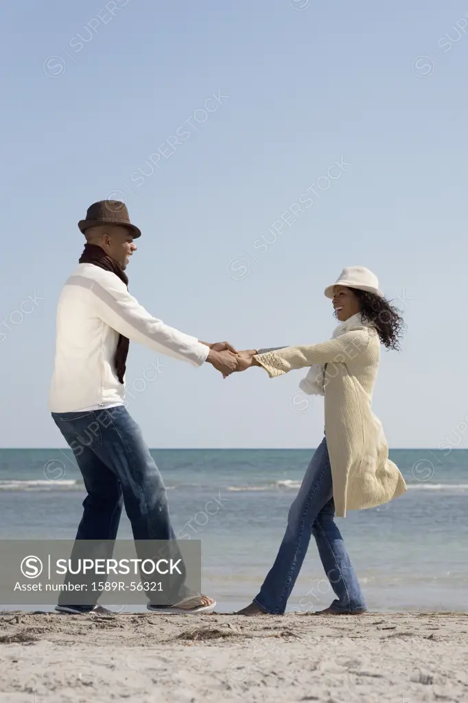 Multi-ethnic couple dancing at beach