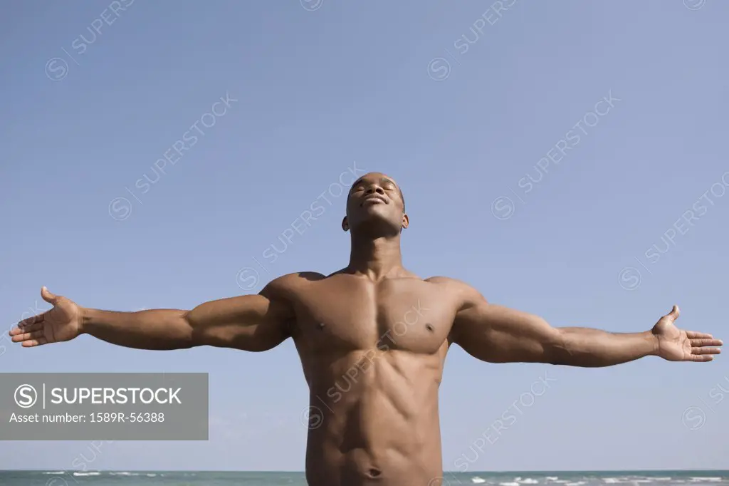 Bare-chested man with arms outstretched