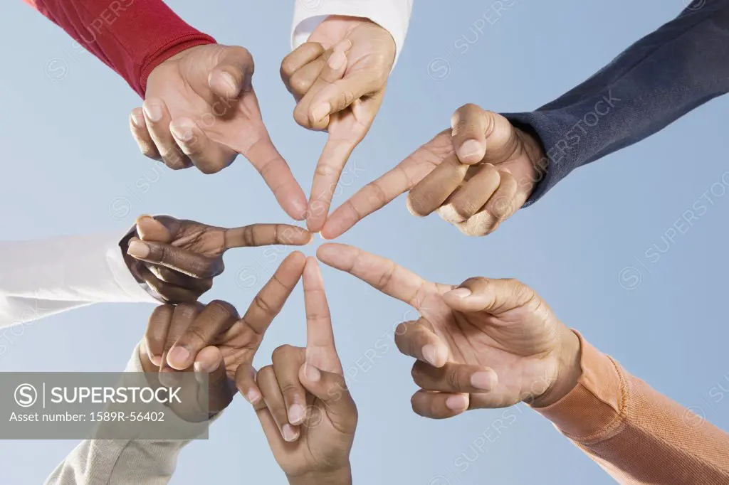 Multi-ethnic friends pointing fingers in circle