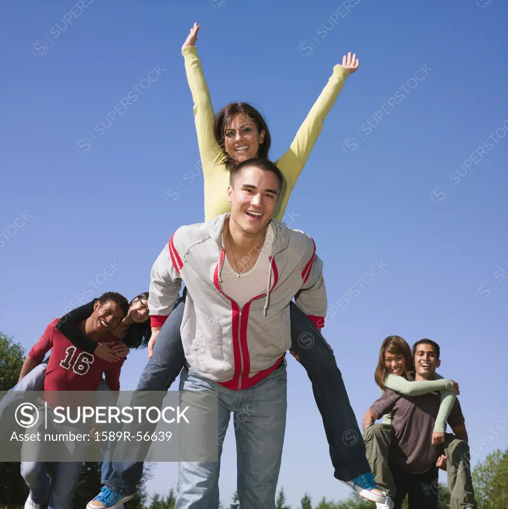 Multi-ethnic couples giving piggy back rides