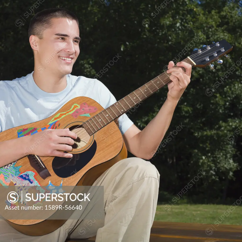 Mixed Race man playing guitar