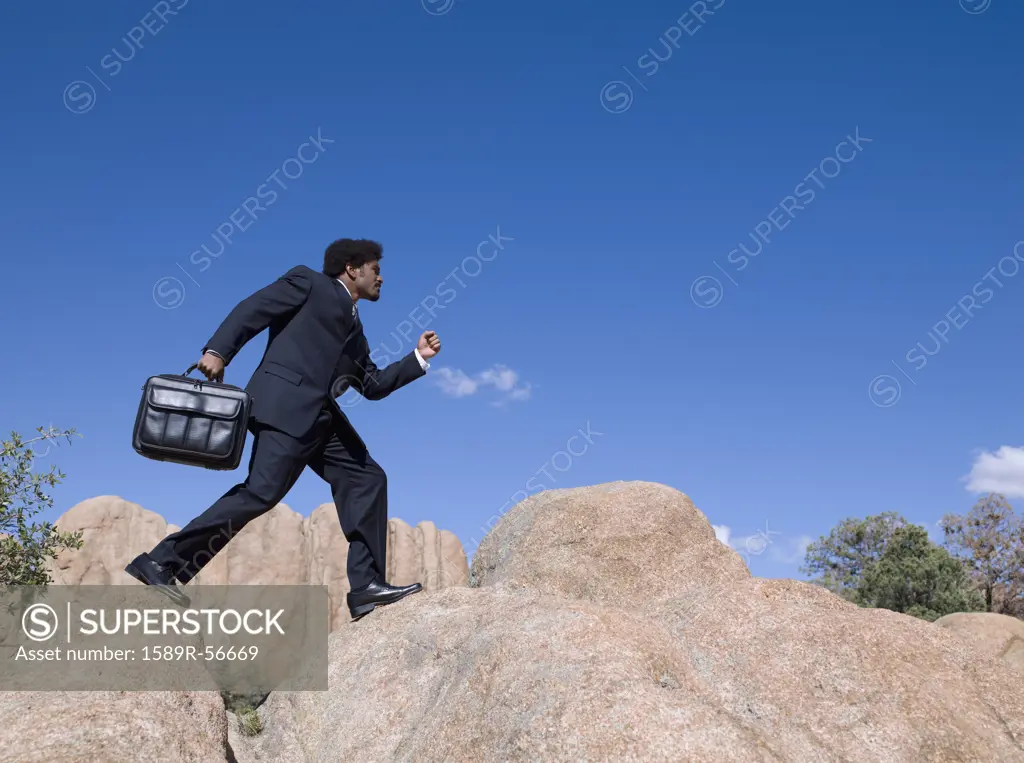 African businessman walking across rocks