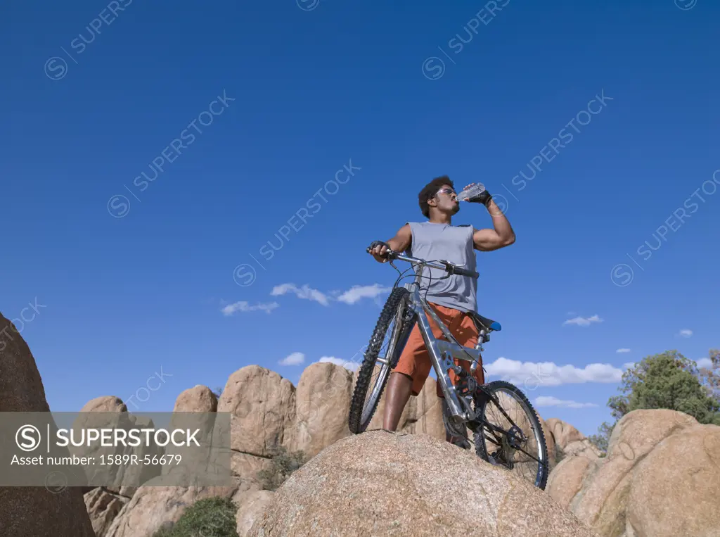 African man with mountain bike on rocks