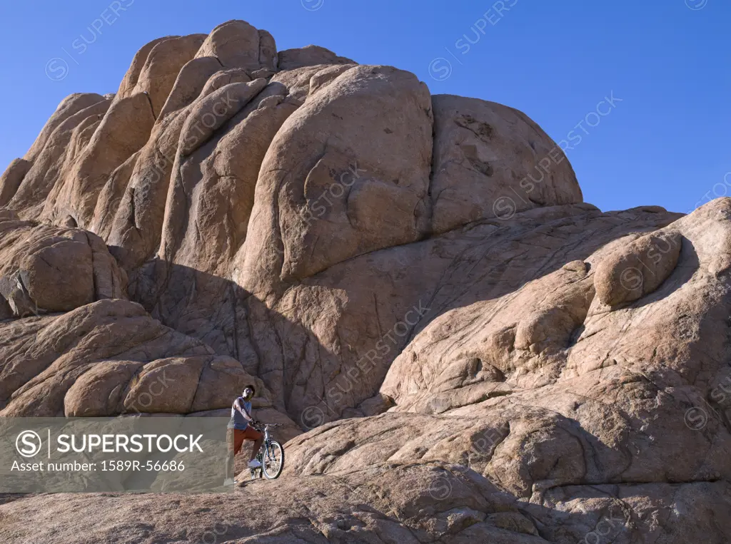 African man with mountain bike on rocks