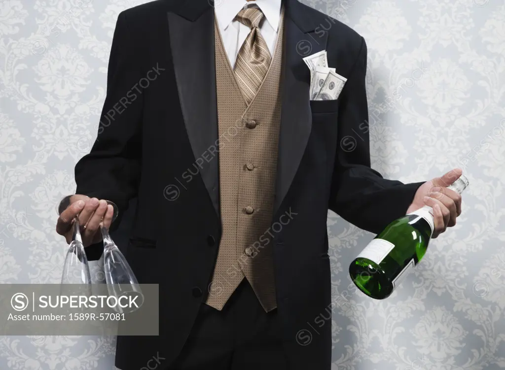 Asian man holding champagne and glasses