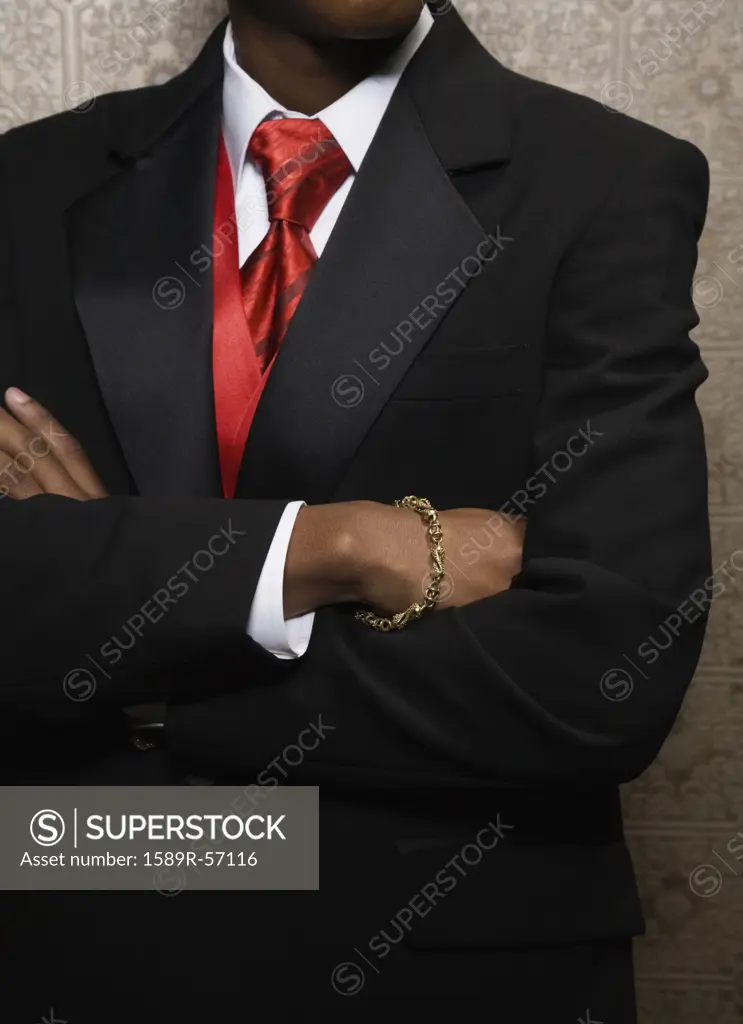 African teenaged boy in suit with arms crossed