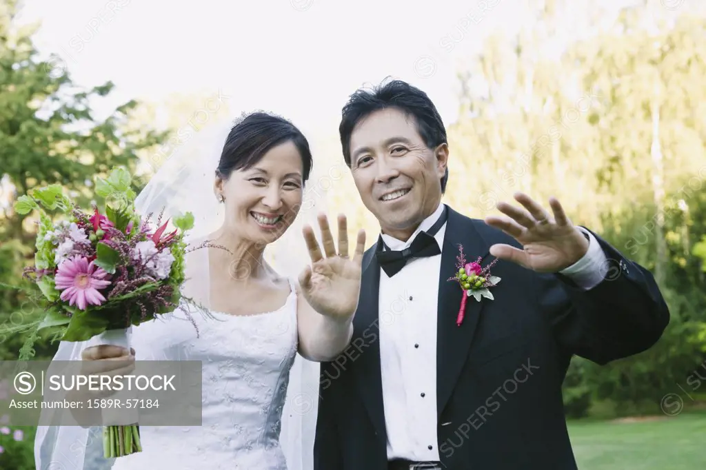 Asian newlyweds waving