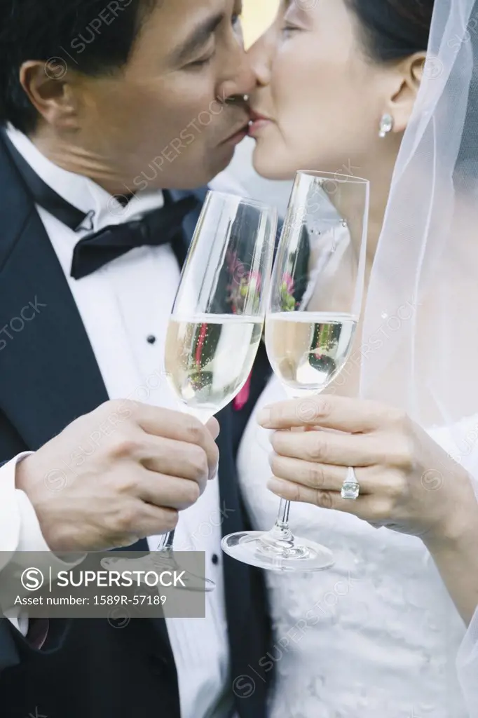 Asian newlyweds kissing