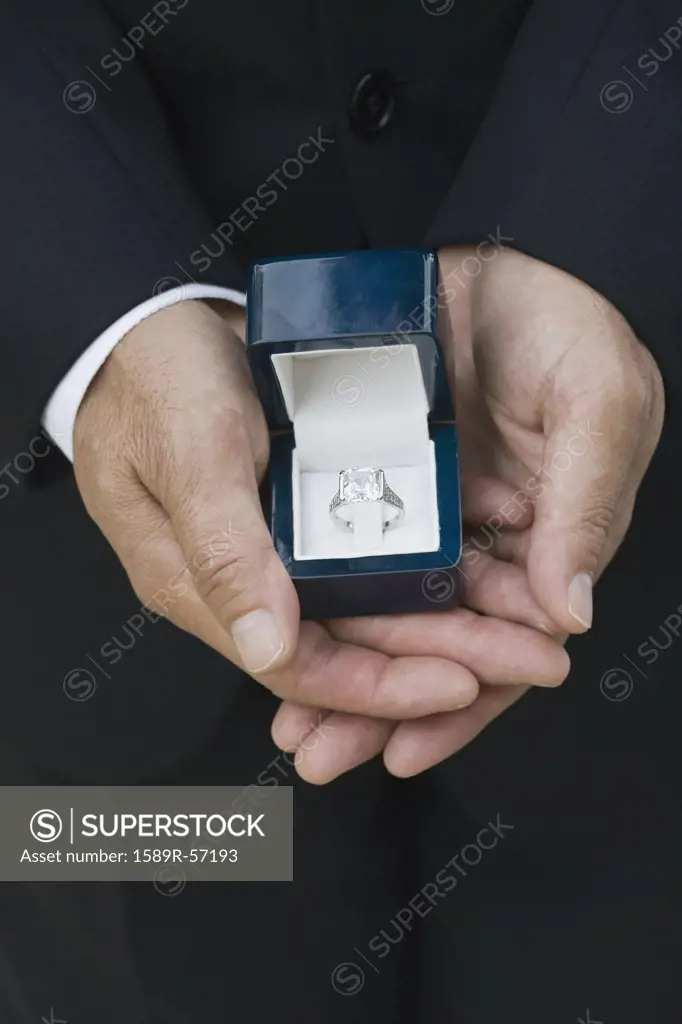 Asian man holding engagement ring