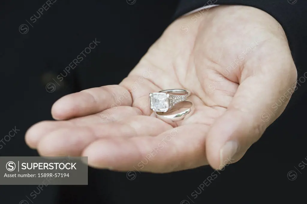 Asian man holding wedding rings
