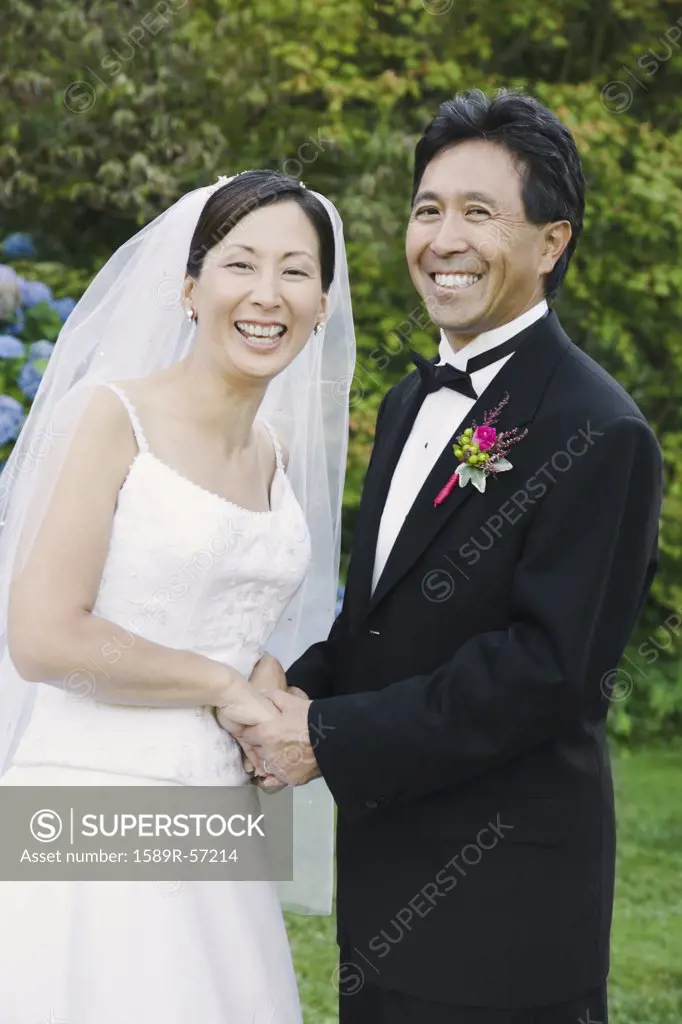 Asian newlyweds holding hands