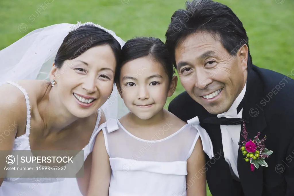 Portrait of Asian newlyweds and daughter