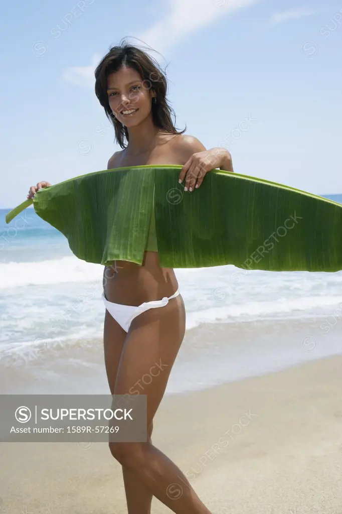 Hispanic woman holding palm frond across chest