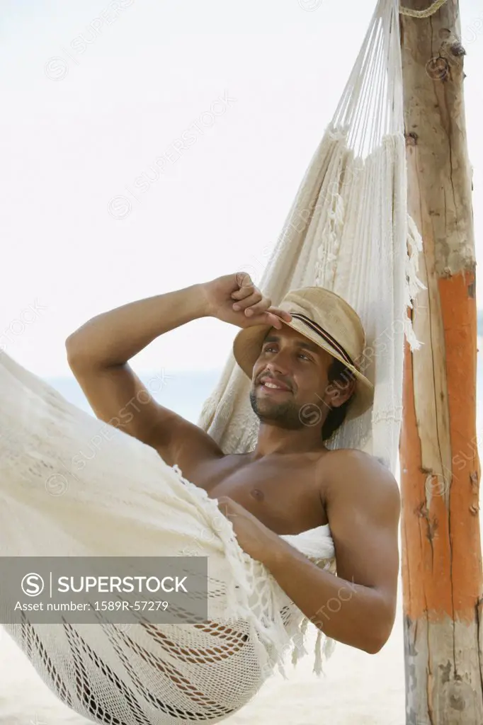 Hispanic man laying in hammock