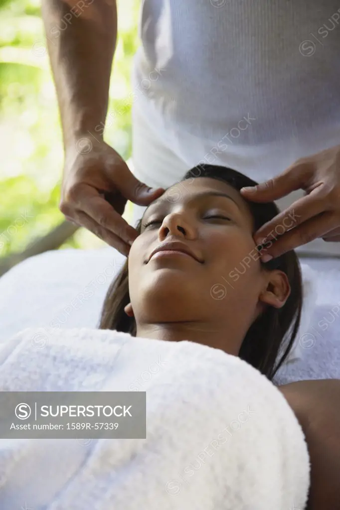 Hispanic woman receiving facial massage