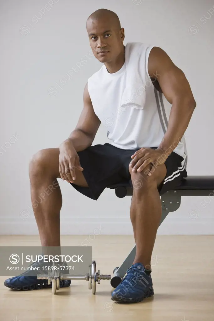 African man sitting on weight bench
