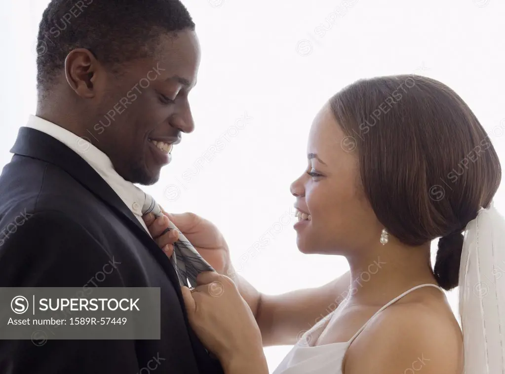 African bride adjusting grooms necktie