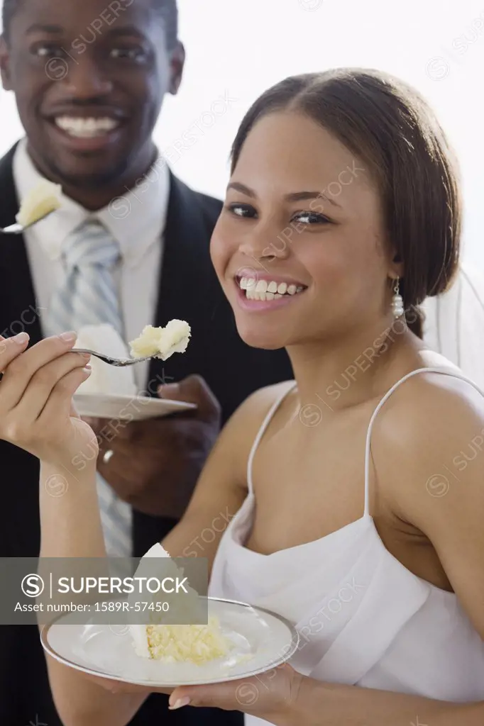 African newlyweds eating cake