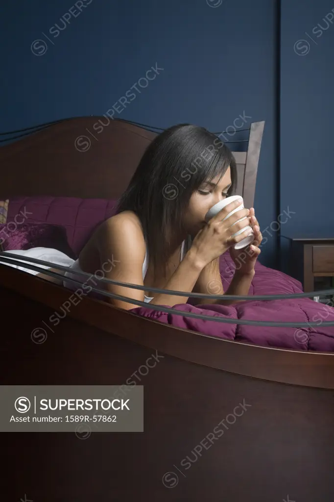 Mixed Race woman drinking coffee