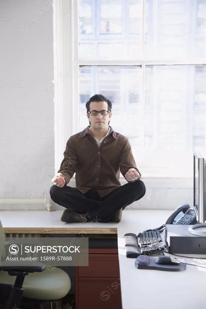 Hispanic businessman meditating