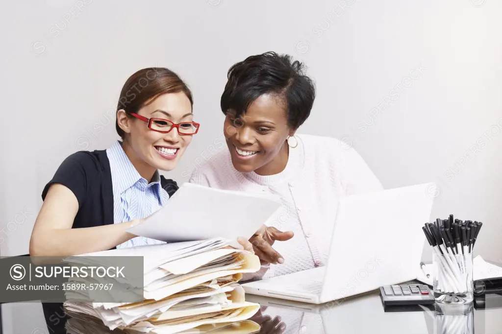 Multi-ethnic businesswomen looking at paperwork
