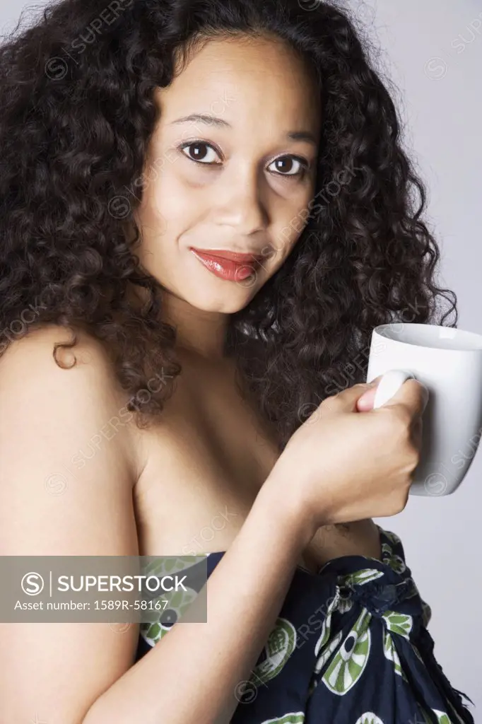 Mixed Race woman holding coffee mug