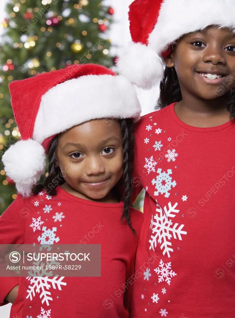 African sisters wearing Santa Claus hats