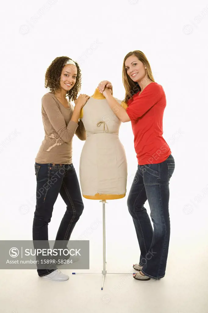 Multi-ethnic women next to dress dummy